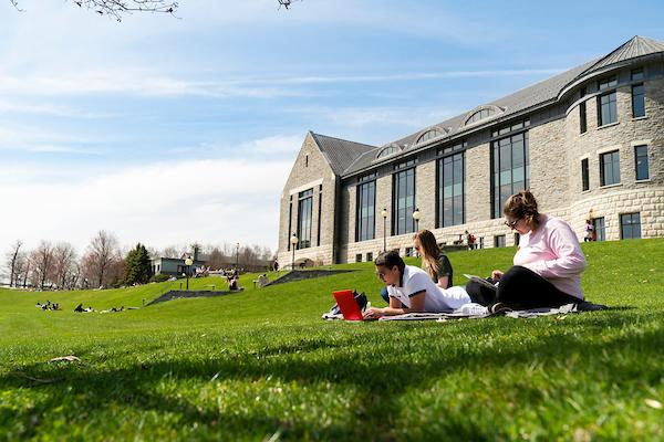 An image of students sitting outside on campus.