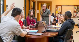 Image of students having a discussion with a professor.